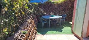 a table and chairs in a garden with a fence at Maison de Vancances à louer Alpes Maritimes in Mouans-Sartoux