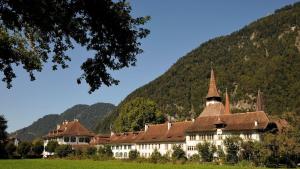 a large building in front of a mountain at alscher's holiday home in Interlaken