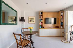 ein Wohnzimmer mit einem Tisch und einem TV in der Unterkunft No 10 in Cheltenham
