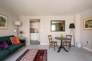 ein Wohnzimmer mit einem grünen Sofa und einem Tisch in der Unterkunft No 10 in Cheltenham