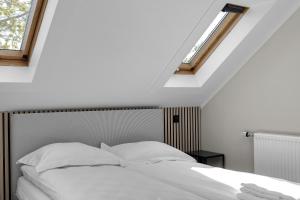 1 dormitorio con 1 cama blanca y 2 ventanas en Central and Cozy Apartment, en Reikiavik