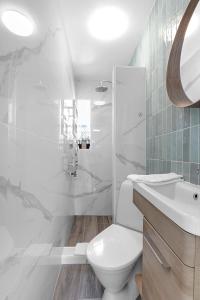 Baño blanco con aseo y lavamanos en Central and Cozy Apartment, en Reikiavik