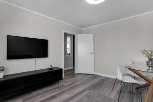 sala de estar blanca con TV y mesa en Central and Cozy Apartment, en Reikiavik
