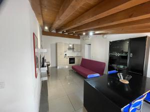 salon z czerwoną kanapą i kuchnią w obiekcie Milano Canal Apartments w Mediolanie