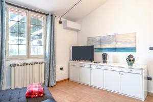 een woonkamer met witte kasten en een flatscreen-tv bij Villa Vincenza in Melilli