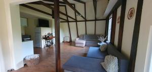 a living room with a couch and a kitchen at Agroturystyka ,, Na Zadupiu,, in Raźny