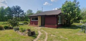 a small red and yellow house in a yard at Agroturystyka ,, Na Zadupiu,, in Raźny