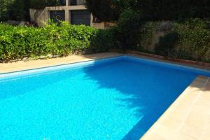uma grande piscina azul ao lado de um edifício em Casa St Llorenc de la Muga em Sant Llorenç de la Muga