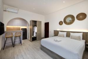 a bedroom with a large bed and a kitchen at Kemari Studio in Canggu