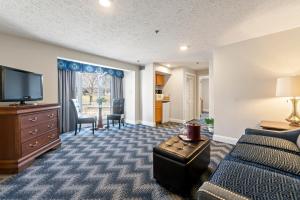 a hotel room with a bed and a flat screen tv at The Grand Hotel in Ogunquit