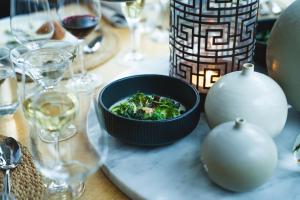 a table with a bowl of food and glasses of wine at Skepparholmen Nacka in Nacka
