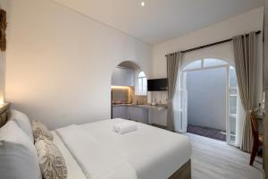 um quarto de hotel com uma cama e uma grande janela em Kemari Studio em Canggu