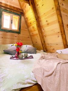 Un dormitorio con una cama y una bandeja con flores. en Eco kutak 2 en Mojkovac