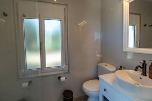 a bathroom with a sink and a toilet and a window at Meraki Mou My pride and care in Spartia +23 photos