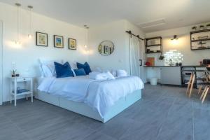 a bedroom with a blue bed and a kitchen at Meraki Mou My pride and care in Spartia