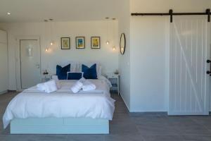 a bedroom with a large white bed with blue pillows at Meraki Mou My pride and care in Spartia