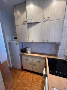  La cuisine est équipée de placards blancs et d'un réfrigérateur. dans l'établissement Central London Apartment - H, à Londres