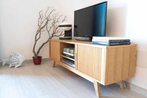 un televisore su un supporto in legno in soggiorno di Blue Vibes ad Alghero