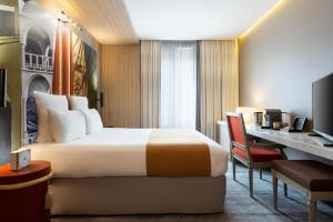 a hotel room with a bed and a desk at Mercure Paris Alesia in Paris