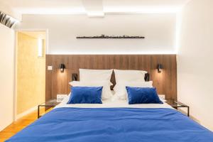 a bedroom with a blue bed with two blue pillows at Cocoon du vieux Lyon - Luxury apartment - Balneo in Lyon