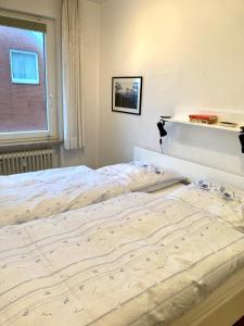a large bed in a bedroom with a window at Dünenschlösschen 22 in Wangerooge +1 photo