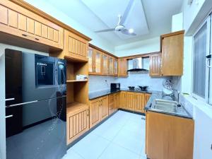 a kitchen with wooden cabinets and a black refrigerator at LUXURY APARTMENT RENTALS in Islamabad