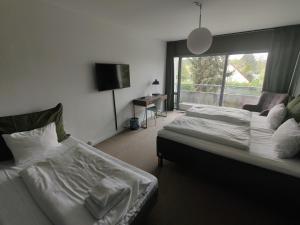 a hotel room with two beds and a window at Hotel Marina in Vedbæk