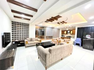 una gran sala de estar con sofás y TV. en LUXURY APARTMENT RENTALS en Islamabad