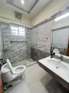 a bathroom with a toilet and a sink and a shower at LUXURY APARTMENT RENTALS in Islamabad