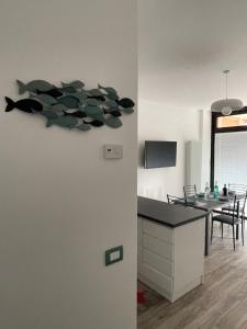 a kitchen and dining room with a fish painting on the wall at Acquamarina 20 in Bergeggi