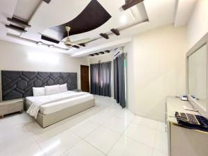 a bedroom with a large bed and a desk at LUXURY APARTMENT RENTALS in Islamabad
