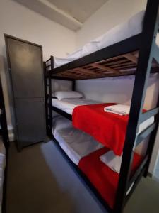 two bunk beds in a room with a red blanket at Oh! Madalena Hostel in Sao Paulo