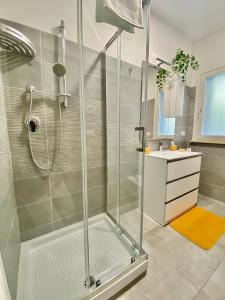 a shower with a glass door in a bathroom at Cava Home - Castelli Apartments in Marino