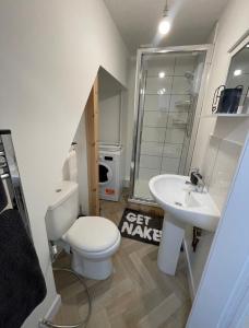 y baño con aseo blanco y lavamanos. en Unique Duplex Apartment FREE parking FREE Wi-Fi 6 minutes from Leeds city centre en Leeds