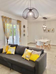 a living room with a gray couch with yellow pillows at Cava Home - Castelli Apartments in Marino