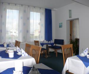 a dining room with blue and white tables and chairs at Hotel Garni - Haus Gemmer in Coburg