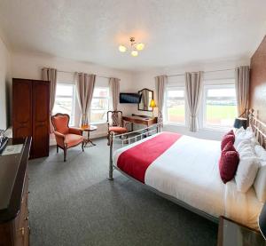 a bedroom with a large bed and a desk and chair at Annabelle Rooms in Great Yarmouth