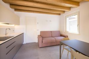 eine Küche und ein Wohnzimmer mit einem Sofa und einem Tisch in der Unterkunft Il Giardino Segreto in Cividale del Friuli