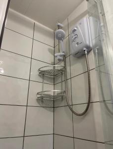 a shower with a blow dryer on a wall at Unique Duplex Apartment FREE parking FREE Wi-Fi 6 minutes from Leeds city centre in Leeds