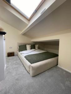 a large bed in a room with a skylight at Unique Duplex Apartment FREE parking FREE Wi-Fi 6 minutes from Leeds city centre in Leeds