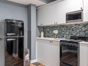 a kitchen with white cabinets and a black refrigerator at VISTA A/B in Washington, D.C.
