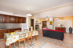 a kitchen and dining room with a table and chairs at Appartamento Acacia in Cala Liberotto