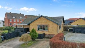 a brick house with a fence in a yard at Kristensen b@b in Hjallerup