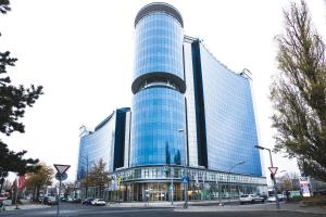 ein hohes blaues Gebäude mit davor geparkt in der Unterkunft Select Hotel Berlin Spiegelturm in Berlin