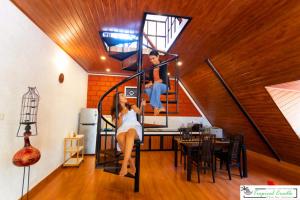 a woman is on a spiral staircase in a house at Tropical Cradle @ River Dale in Kalyānpur