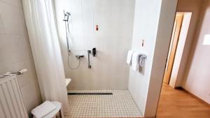 a bathroom with a shower with a toilet and a sink at Hotel Kindler 2,0 Self-Check-In in Leoben
