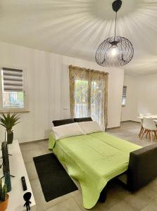 um quarto com uma cama com um cobertor verde em Cava Home - Castelli Apartments em Marino