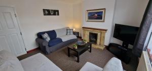 sala de estar con sofá y chimenea en VH, 4 BR House, Upwell, Wisbech, en Upwell