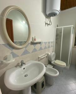 a bathroom with a sink and a toilet and a mirror at Casa Gaia in Avola