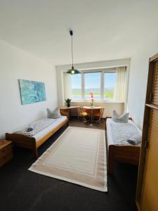 a room with two beds and a table with a window at H1 Herberge-One Erfurt in Erfurt